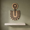 Abstract Mask Design 1 in black patterned palm leaves, handwoven in Malawi, displayed on a wall