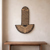 Abstract Mask Design 3 in black patterned palm leaves, handwoven in Malawi, displayed on a wall
